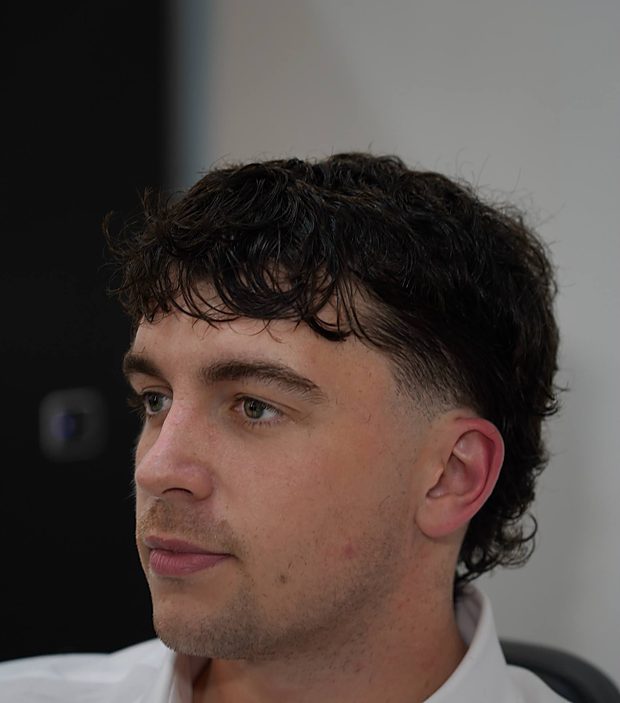 Textured curly crop with a low taper fade — men's haircut by The Art of Perfection Barbershop, Midtown Manhattan
