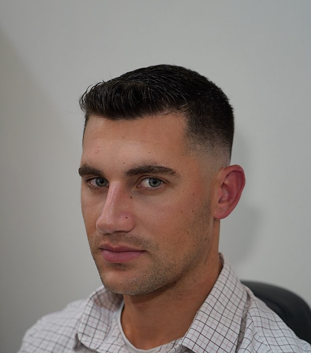 Classic short crop with a clean mid fade and sharp hairline — men's haircut at The Art of Perfection, Midtown Manhattan